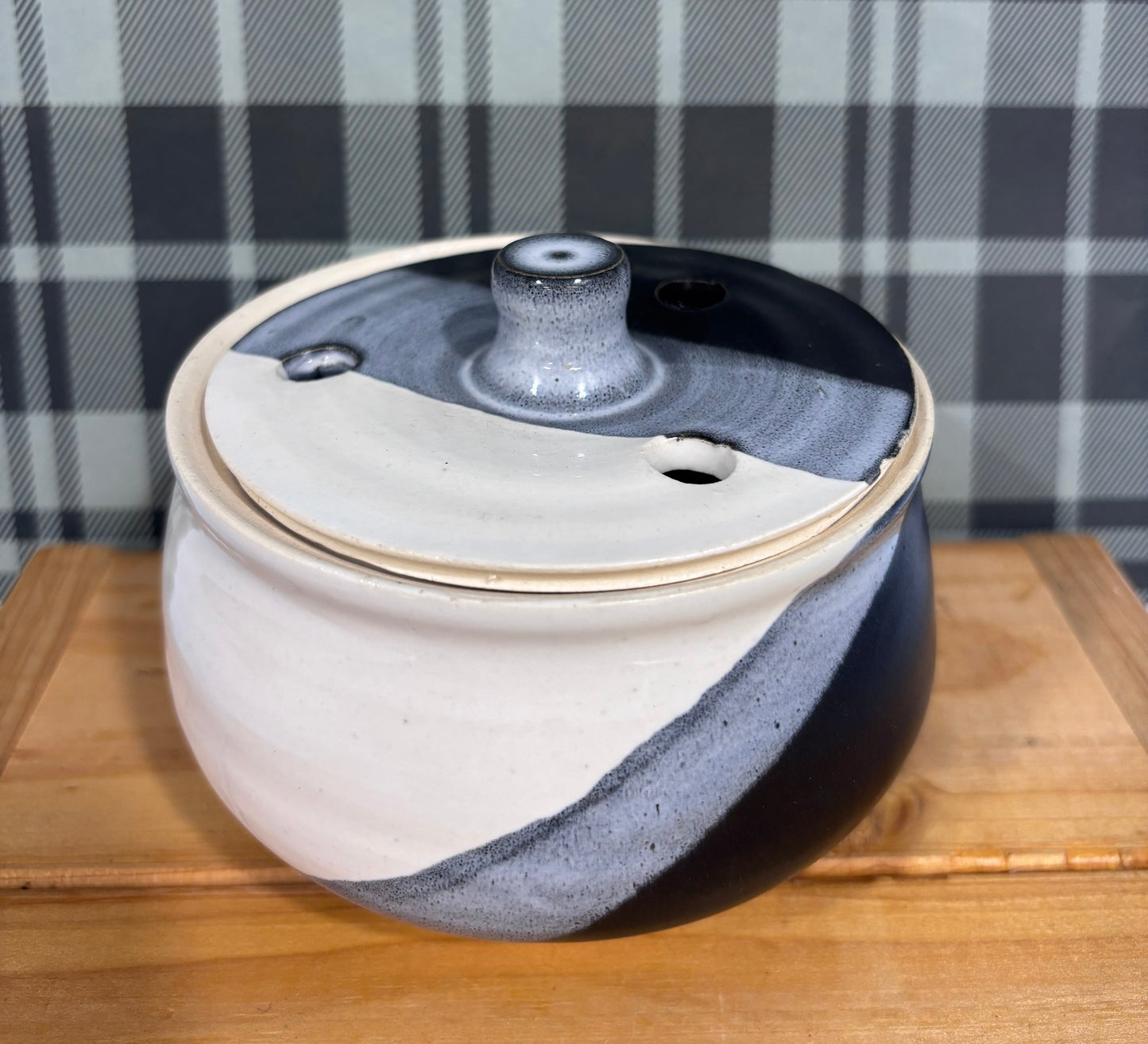 Round ceramic dish with blue and white design on a checkered fabric background